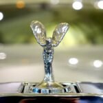 Detailed shot of a luxury car emblem reflecting the elegance and style of automobile design.